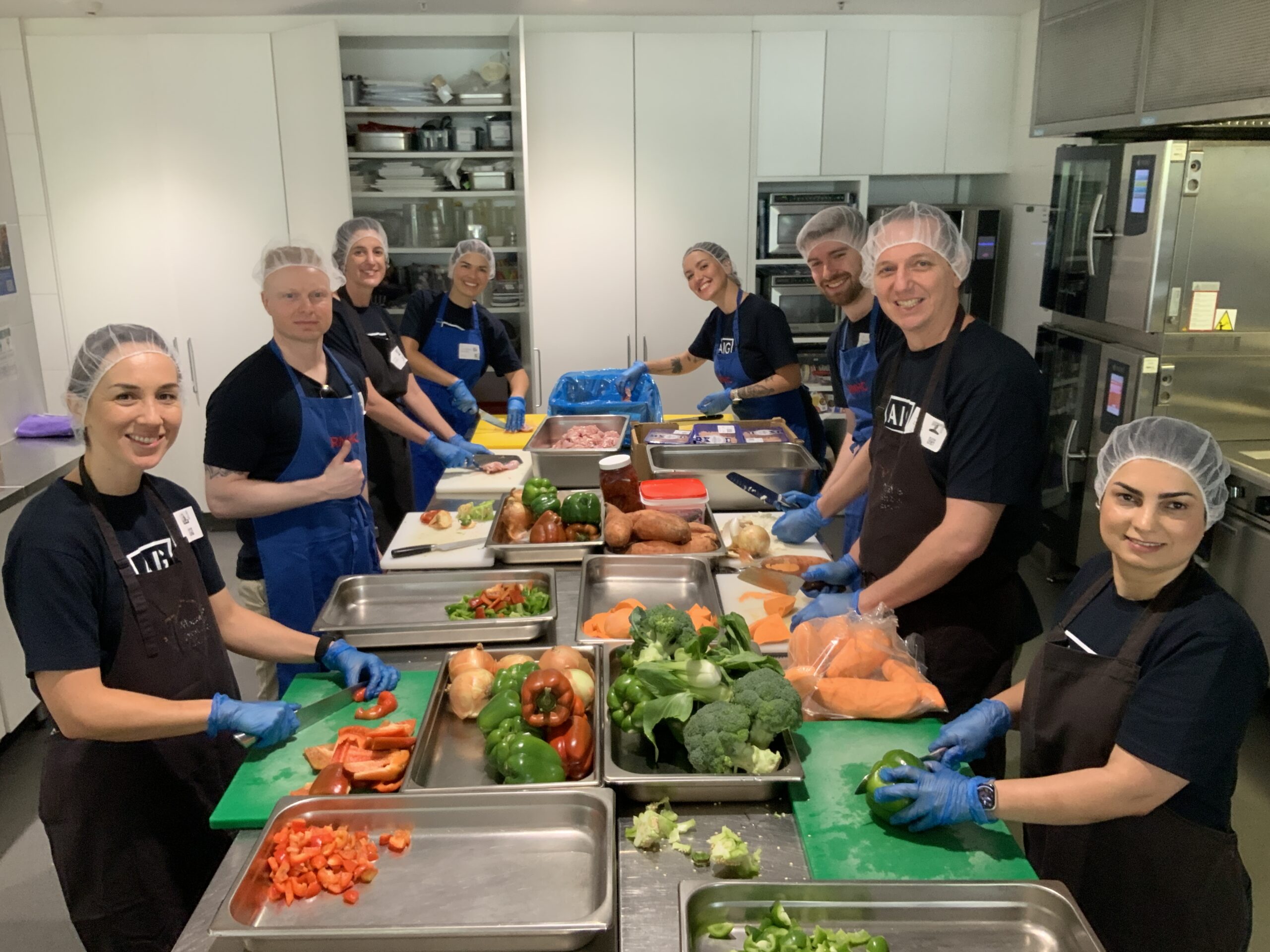 AIG in the kitchen at Ronald McDonald House Greater Western Sydney Westmead, preparing ready-made meals for families as part of the Cook + Connect group volunteering program