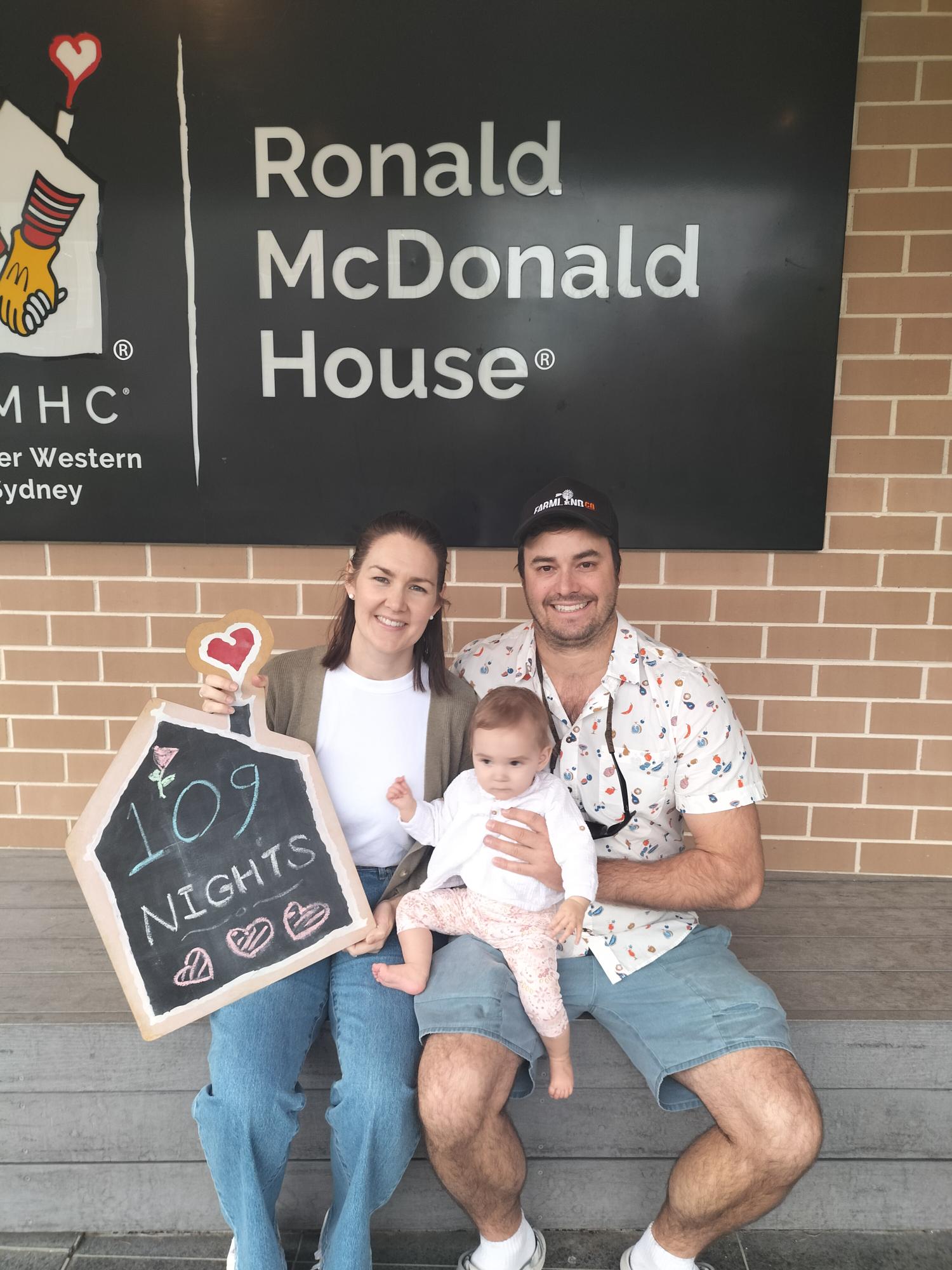 Family holding up a sign that says "109 nights" to indicate the # of nights of support by Ronald McDonald House Greater Western Sydney